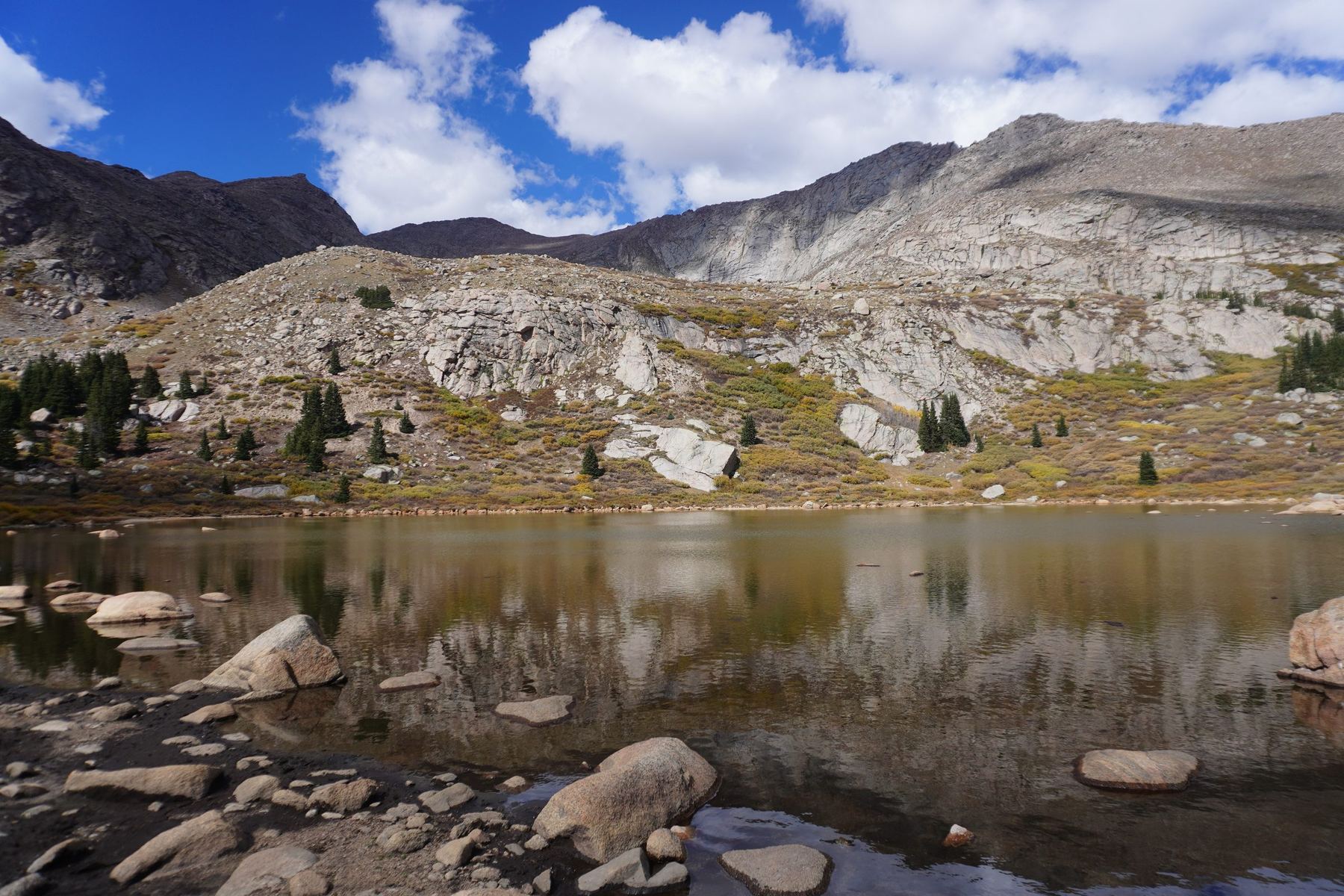 Alpine lake reflecting rocky peaks and clouds near Guanella Pass